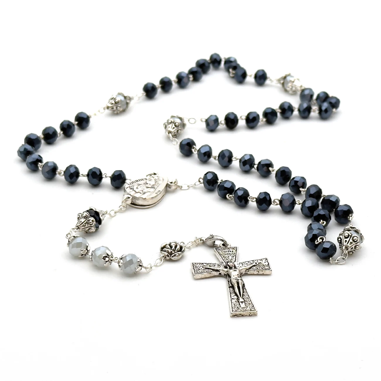 Chapelet de Lourdes en perles de verre facettées noir bleuté – finitions argentées et croix stylisée – présenté dans sa boîte plastique