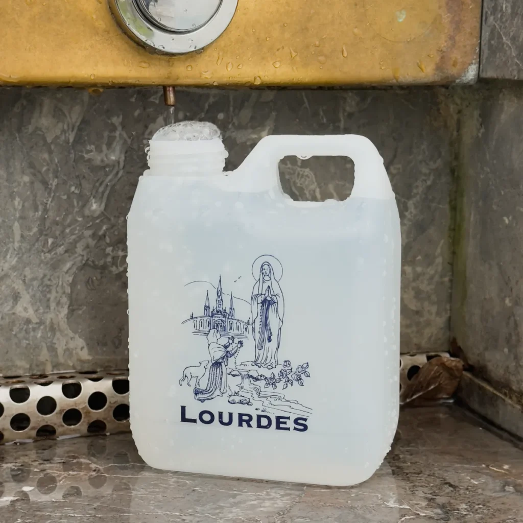 Bidon Lourdes d’un litre en cours de remplissage sous une fontaine du Sanctuaire