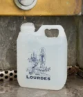 Bidon Lourdes d’un litre en cours de remplissage sous une fontaine du Sanctuaire